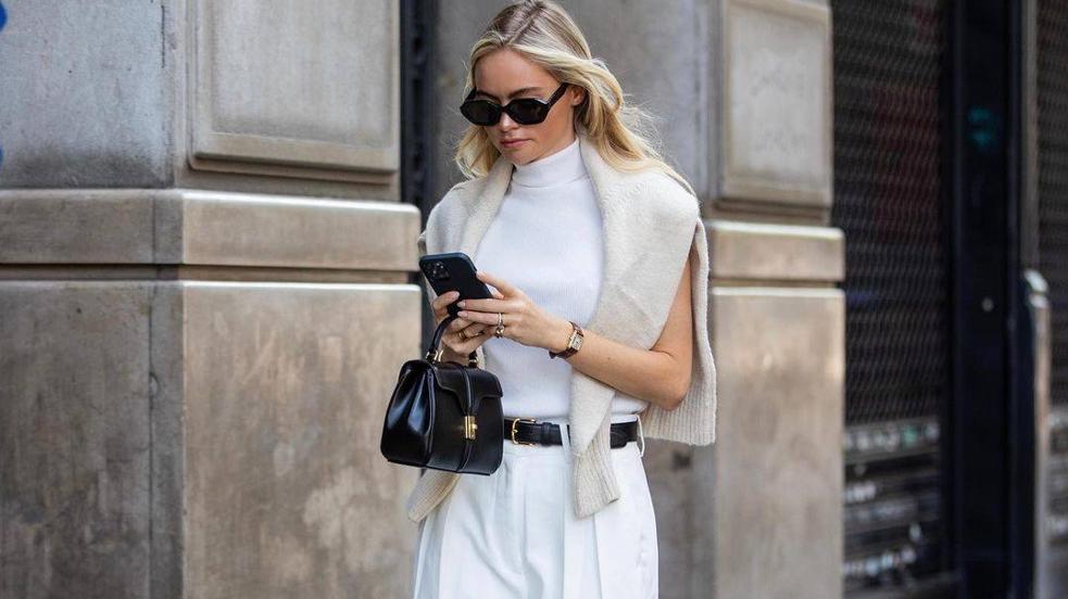 La influencer lleva un total look blanco de oficina con chaleco de punto con cuello alto
