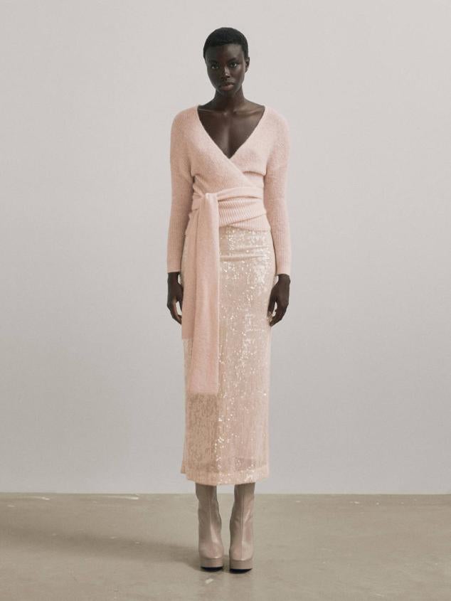 Falda larga de lentejuelas con tiro alto, forro y abertura posterior en el bajo, en tono rosa maquillaje, de Massimo Dutti. Está disponible por 129 euros.