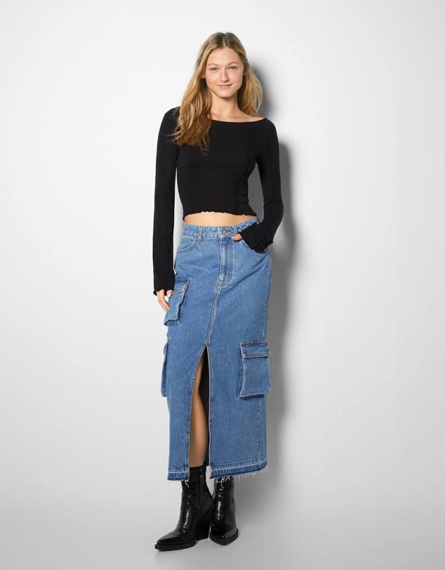Falda larga en tejido denim con tiro alto, bolsillos, abertura frontal y bajo sin rematar, color azul, de Bershka. Encuéntrala por 35,99 euros.