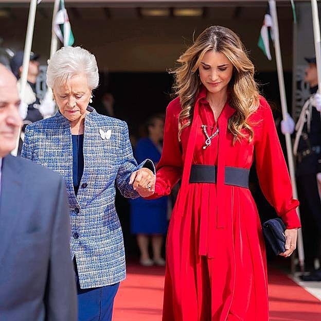 La reina Rania de Jordania le da la mano a su suegra, la princesa Muna