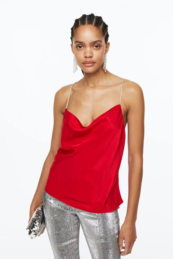 Top lencero en tejido satinado con tirantes finos de cristales que se unen en la espalda y escote fluido, en rojo, de H&M. Está disponible por 14,99 euros.