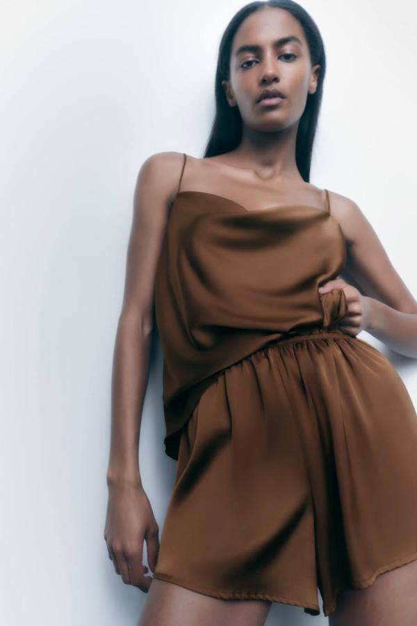 Top lencero en tejido satinado con tirantes finos y escote fluido, color marrón, de Zara. Lo encontrarás a 17,95 euros.