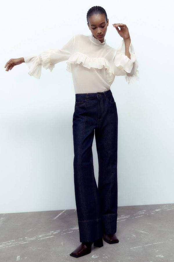 Blusa en tejido ligero semitransparente con cuello subido, manga larga y aplicación de volantes, de Zara. Puedes comprarla por 25,95 euros.