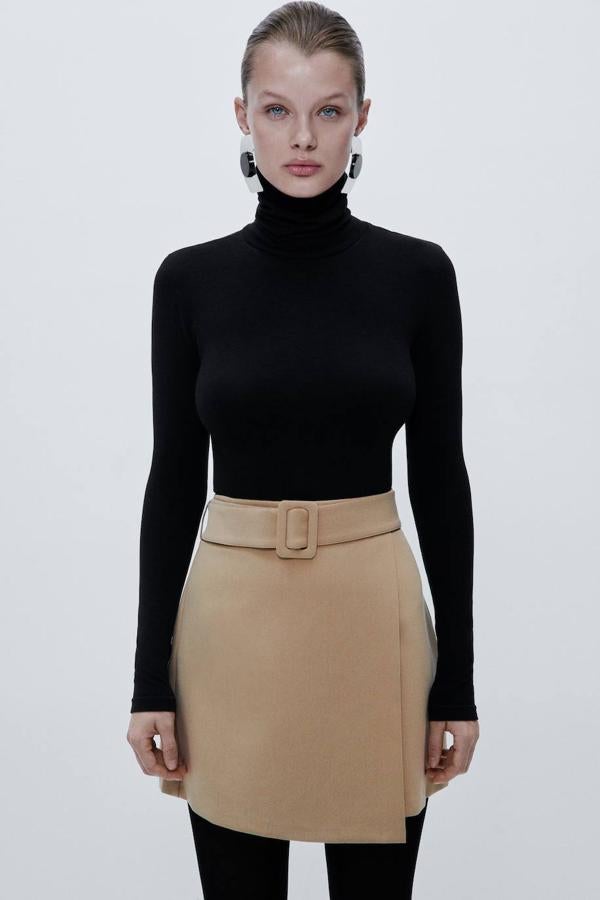 Falda corta con diseño cruzado, tiro alto y cinturón con hebilla a juego, tono tostado, de Zara. Su precio es de 29,95 euros.