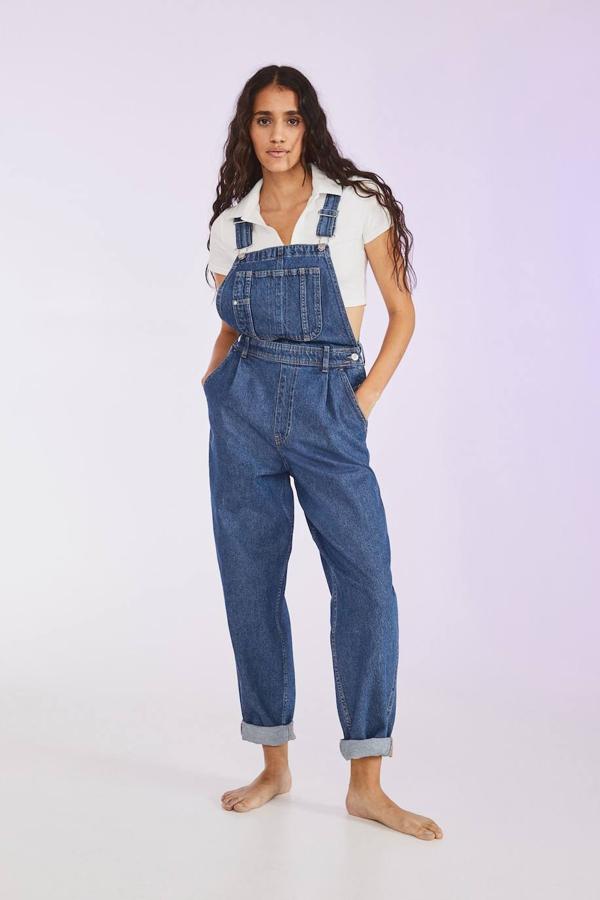 Peto en tejido denim con perneras estilo mom fit, escote cuadrado, tirantes anchos ajustables, detalle de pinzas, bolsillos y trabillas para el cinturón, en azul medio, de H&M. Su precio es de 39,99 euros.