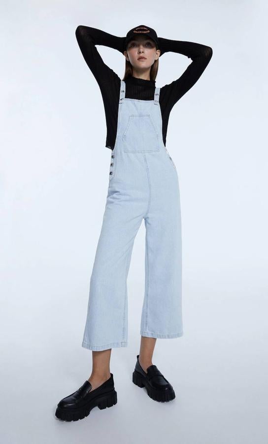Peto denim con perneras tipo culotte de largo cropped, cierre de botones, tirantes ajustables y bolsillos, en azul claro, de Stradivarius. Cómpralo a 29,99 euros.