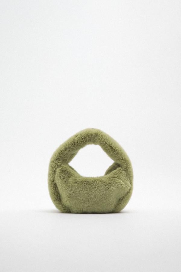 Bolso de hombro en tejido efecto pelo con forma de media luna, en tono verde agua, de Zara. Puedes encontrarlo a 25,95 euros.
