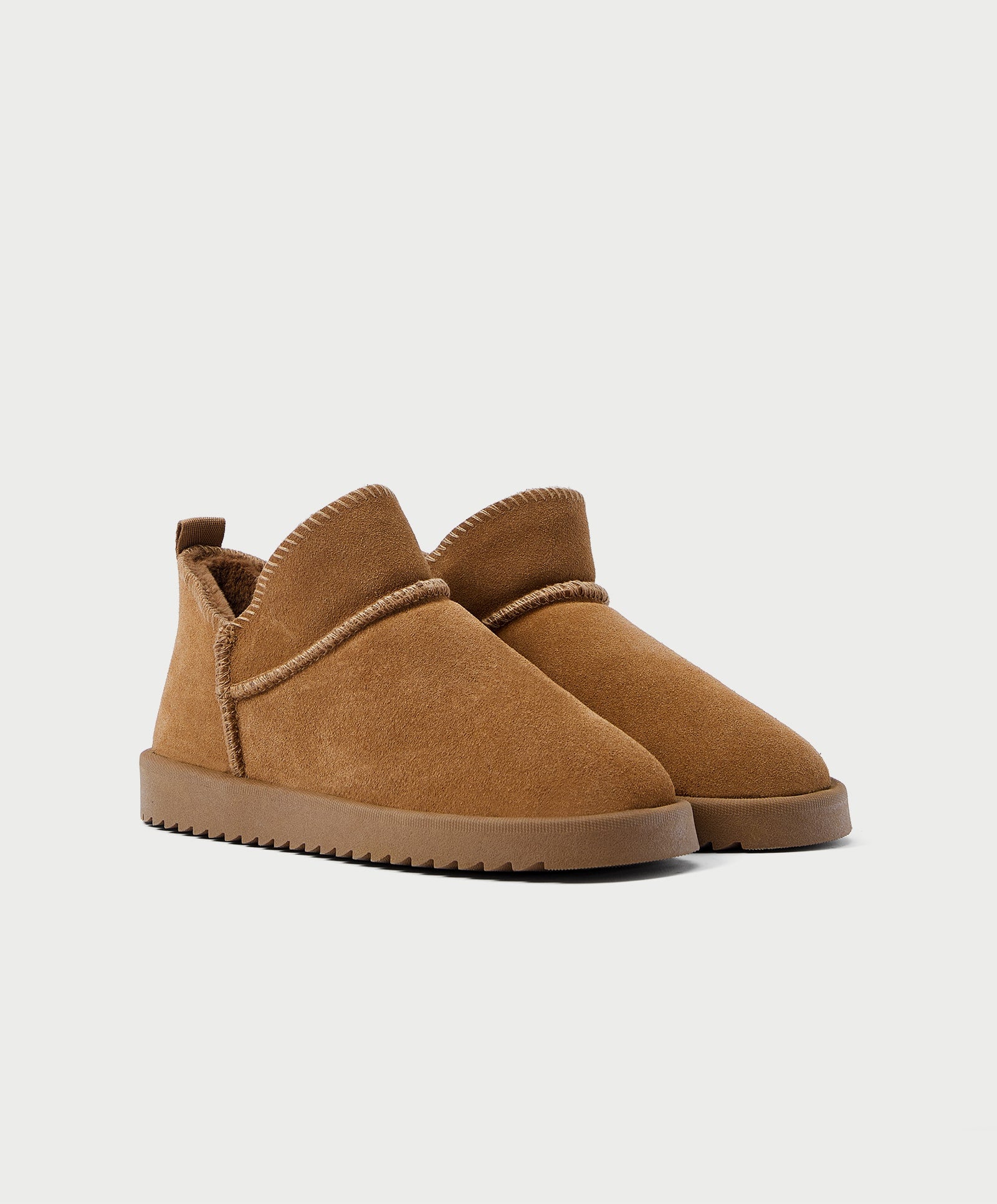 Botín de piel con forro interior de pelo en color marrón tostado de Oysho (29,99 euros).