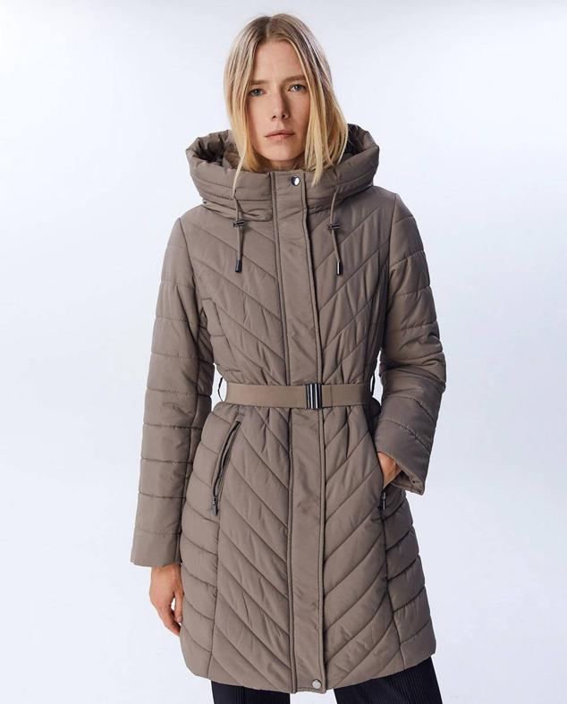 Parka en tejido acolchado con capucha, cuello alto, bolsillos y detalle de cinturón elástico, en tono topo, de Sfera. Cuesta 49,99 euros.