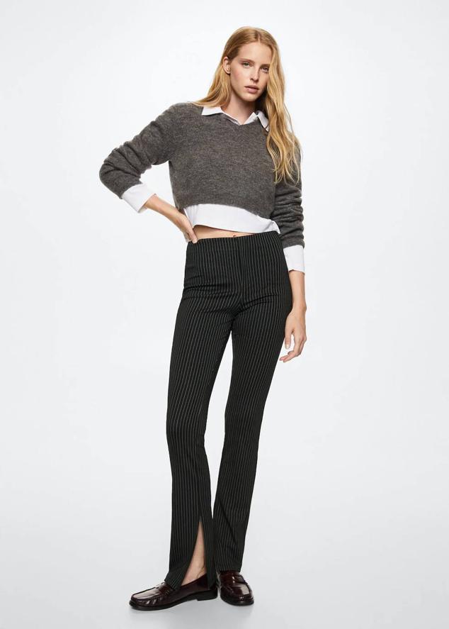 Pantalones entallados con tiro alto, abertura en el bajo y estampado de raya diplomática, de Mango. Cómpralos por 25,99 euros.