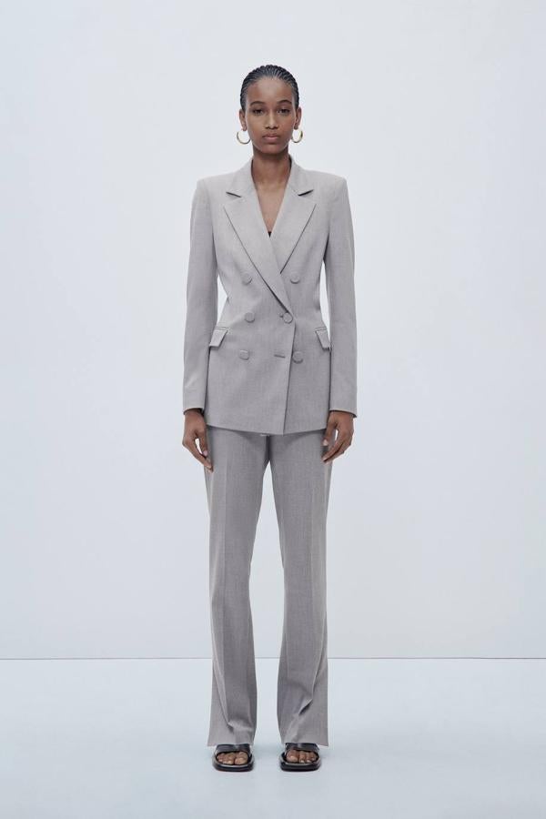 Pantalón de traje pitillo con tiro medio, raya marcada y abertura en el bajo, tono gris claro, de Zara. Su precio es de 29,95 euros.