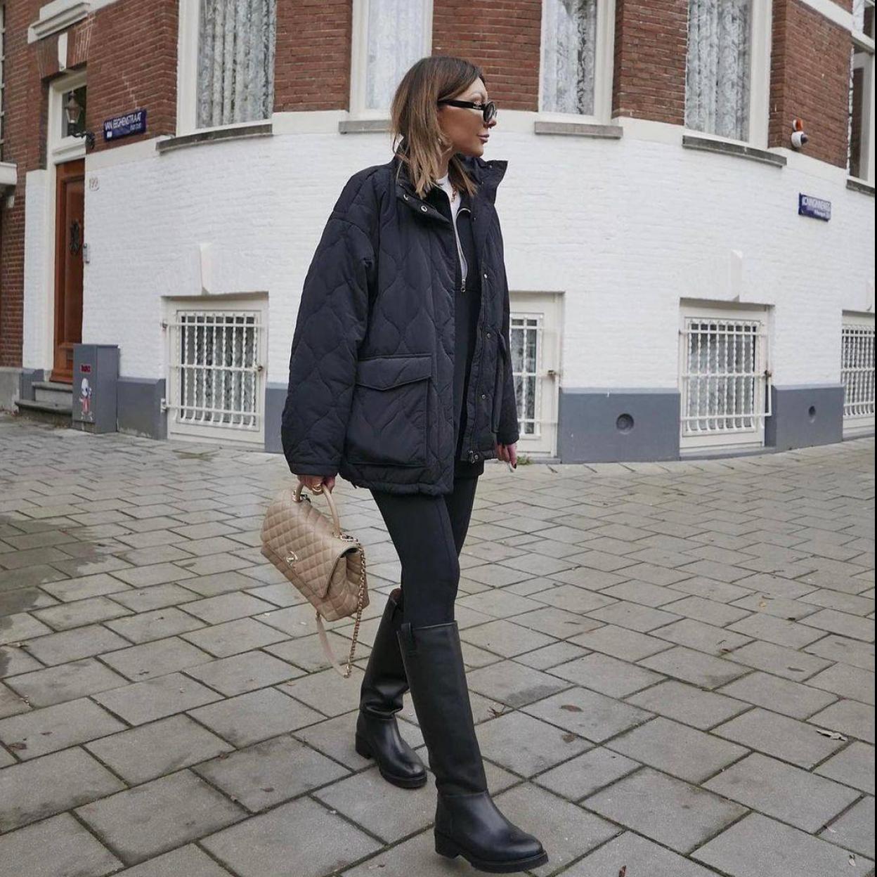 La influencer lleva un look con botas altas planas en negro