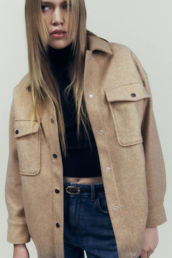 Sobrecamisa en tejido soft con manga larga, cuello solapa, bolsillos de plastrón y cierre de botones a presión, color tostado. Puedes comprarla a 29,95 euros.