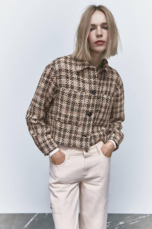 Sobrecamisa en tejido de estructura con diseño cuadrado, manga larga, cuello solapa, bolsillos y estampado de cuadros en tonos marrón. La encontrarás a 39,95 euros.