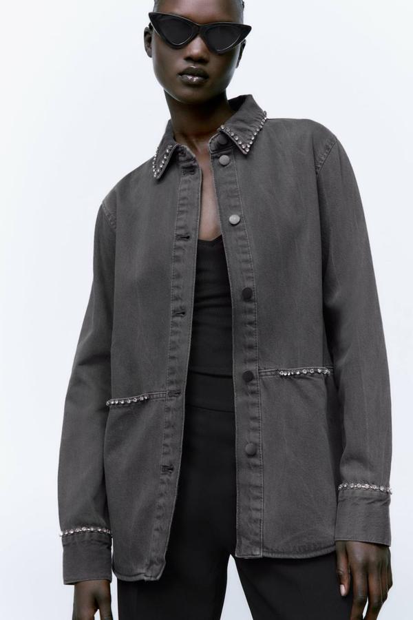 Sobrecamisa en tejido denim con cuello solapa, manga larga, detalle de aplicación de pedrería y cierre de botones, en gris. Cómprala por 39,95 euros.