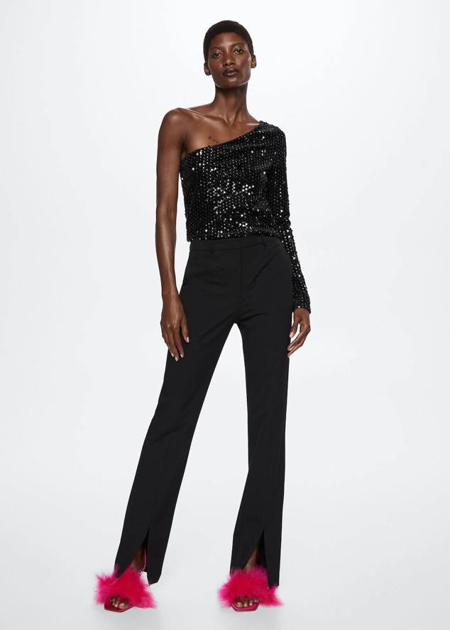 Top con diseño asimétrico, una manga larga y adornos de lentejuelas a tono, en color negro, de Mango. Te costará 25,99 euros.