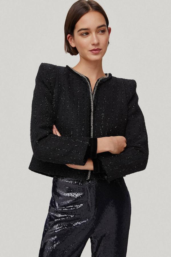 Chaqueta en tejido de tweed con cuello redondo, manga larga, hombreras y detalle de hilo metalizado, en negro, Pedro del Hierro. Está disponible en Cortefiel a 124,50 euros.