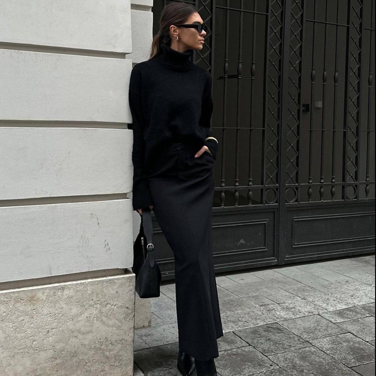 La influencer lleva un total look black con falda negra