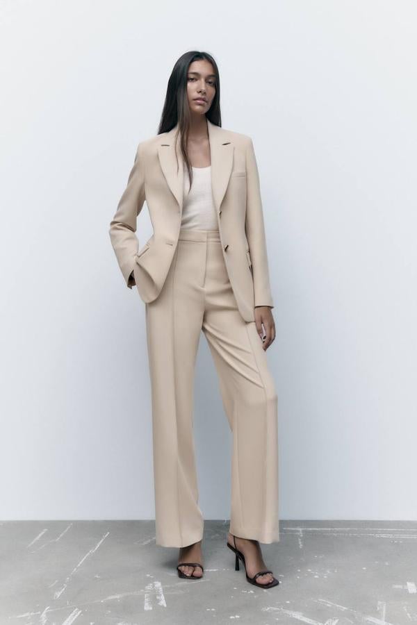 Traje de dos piezas con americana entallada y pantalón de vestir con nervio central, color arena, de Zara.
