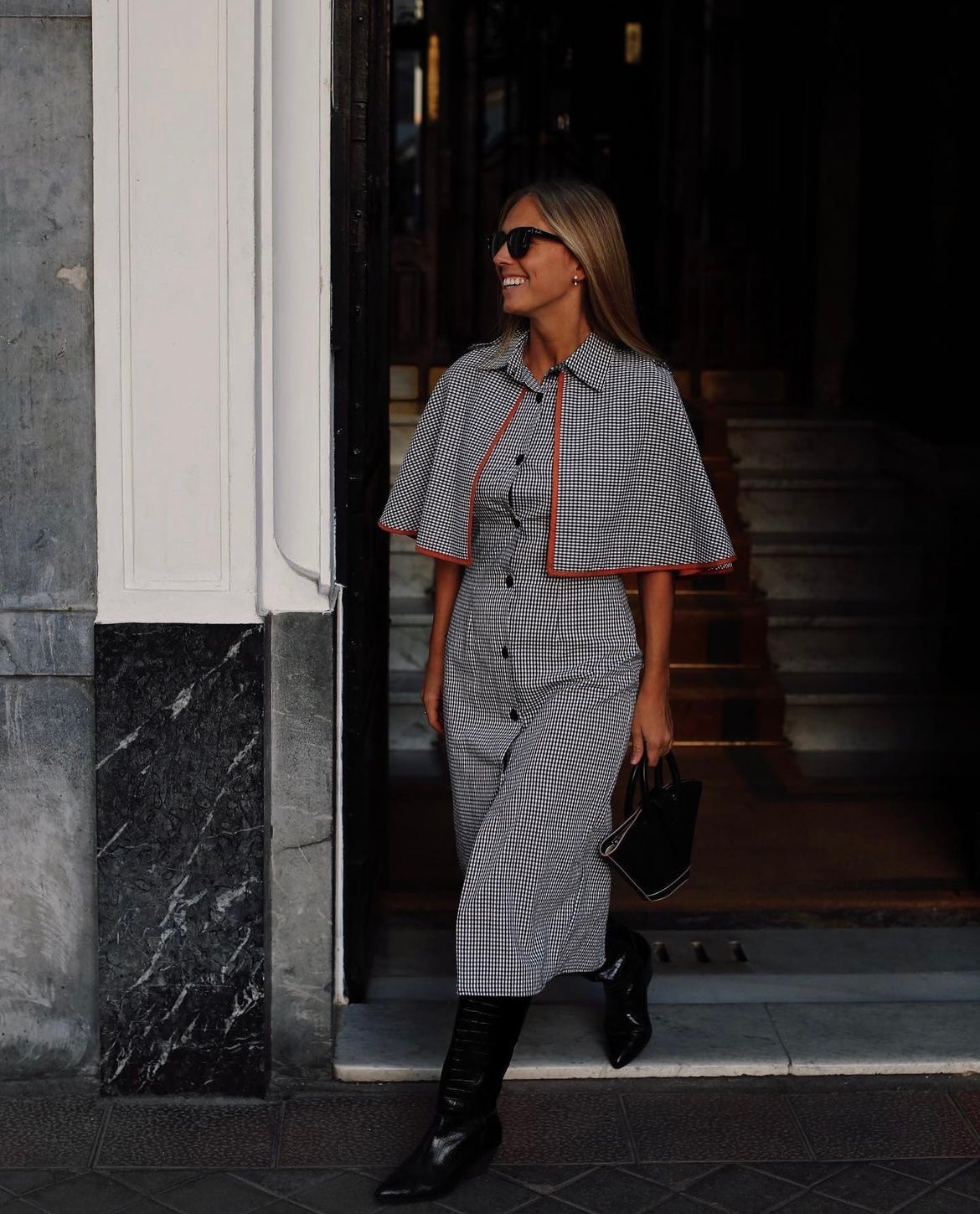 El boom por las botas altas ha sido tal que hasta han sustituido a los botines en muchos casos, tal y como se puede apreciar en la imagen. Antes de que Emily in París dictara esta tendencia a favor de este calzado perfecto para el invierno, los botines eran los fieles compañeros de los vestidos midi en cualquier look. Pero ahora ya no, las que más saben de estilo eligen las botas altas para elevar sus outfits. Ese ha sido el caso de la influencer Lucía Barcena, que ha combinado un vestido con estampado vichy blanco y negro con unas botas altas con efecto piel de cocodrilo. 