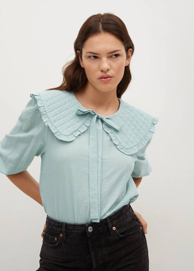 Blusa romántica con cuello babydoll, detalle de lazada, mangas largas abullonadas y cierre de botones, en verde pastel. Cómprala a 12,99 euros.