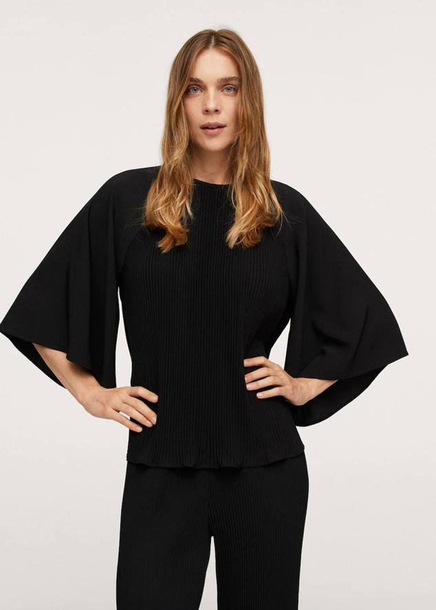 Blusa fluida en tejido plisado con cuello redondo y mangas tres cuartos acampanadas, color negro. Consíguela a 15,99 euros.