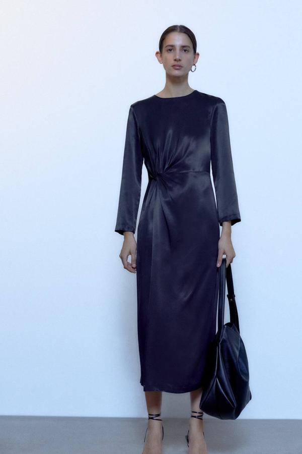 Vestido midi satinado con detalle de nudo fruncido, manga larga y cuello redondo. Su precio rebajado es de 29,99 euros.