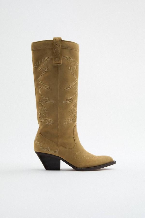 Botas cowboy en tejido efecto ante con costuras decorativas, tiradores, acabado en punta y tacón ancho, tono marrón, de Zara. Están disponibles de rebajas por 59,99 euros.