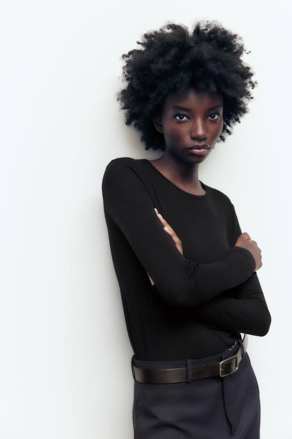 Camiseta en tejido semitransparente con corte ajustado, cuello redondo y manga larga. Su precio es de 9,95 euros, en tres colores.