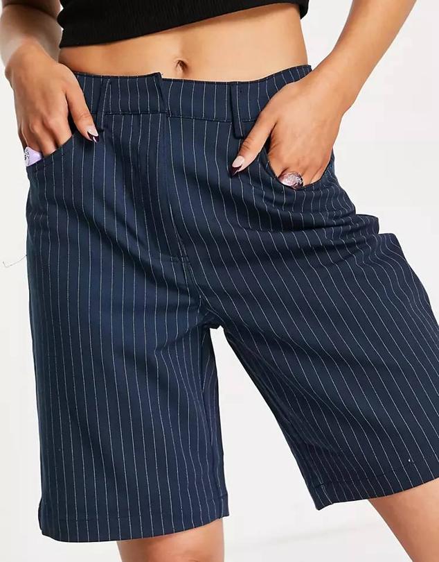 Bermudas de vestir con tiro medio, trabillas para el cinturón, bolsillos y estampado de raya diplomática azul marino, de Asos.