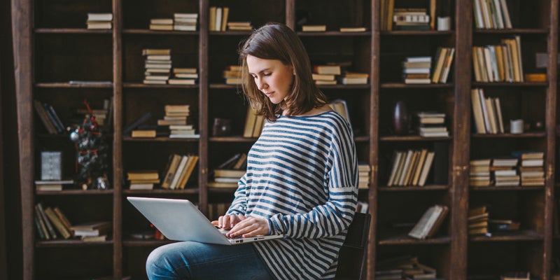 Young woman using laptop in the library
