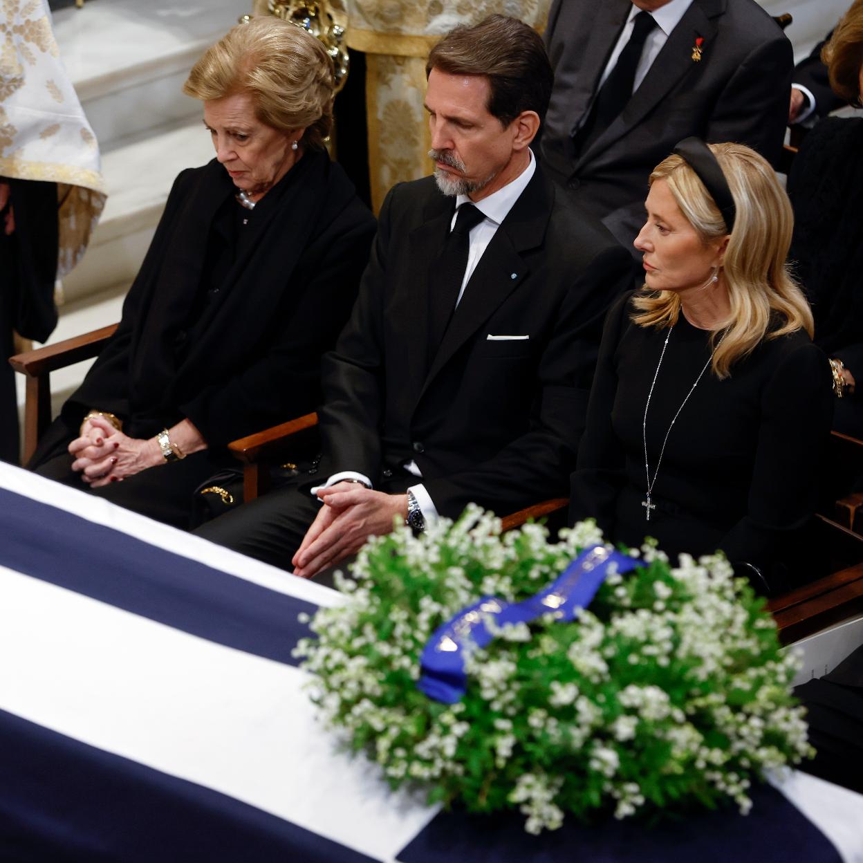 Ana María de Grecia, su hijo Pablo y la mujer de este, Maroe-Chantal Miller, frente al féretro de Constantino de Grecia en su funeral en la catedral Metropolitana de Atenas. 