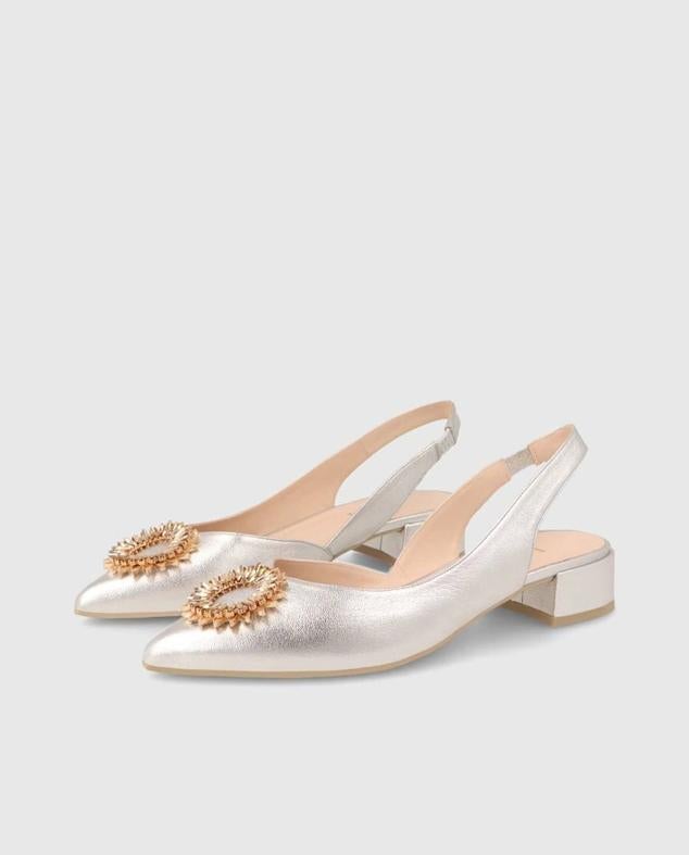 Bailarinas efecto metalizado, destalonadas con tira trasera, acabado en punta, tacón bajo y hebilla de joya, tono plata, de Lodi. Hazte con ellas rebajas a 101,50 euros.