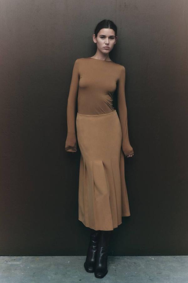 Falda midi de trio alto con bajo acabado en tablas, en tono camel, de Zara. Su precio rebajado es de 19,99 euros.