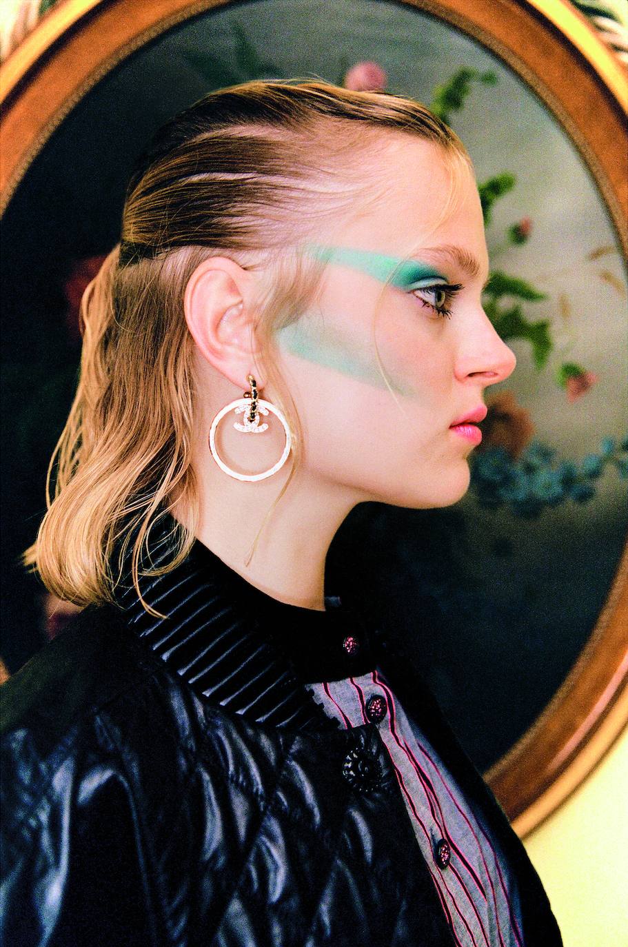 Camisa, chaleco y pendientes, de Chanel. 