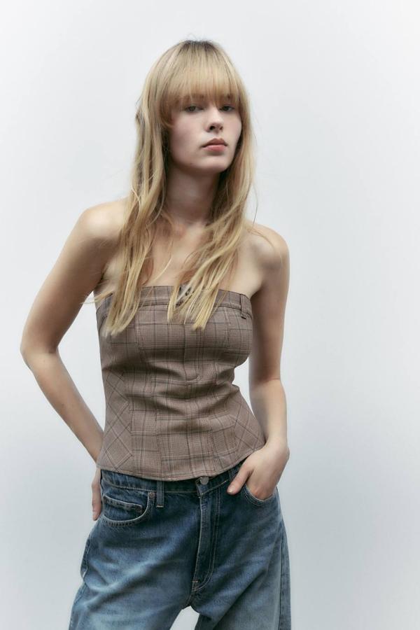Top corsetero ajustado con escote recto y hombros al descubierto, en estampado de cuadros marrón, de Zara. Puedes comprarlo en rebajas por 7,99 euros.