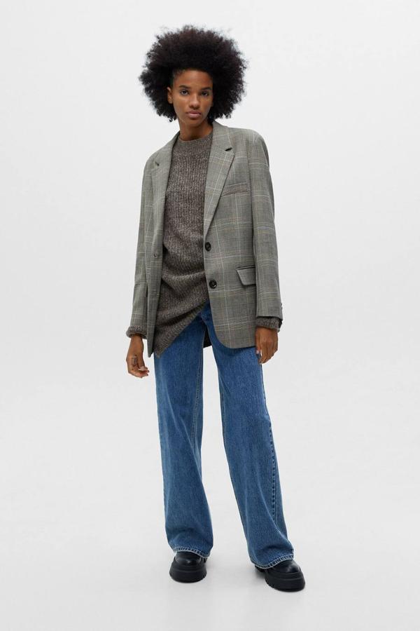 Blazer con corte recto, cuello solapa, manga larga, bolsillos y estampado a cuadros en tonos marrón, de Pull&Bear. Te costará 19,99 euros, en rebajas.