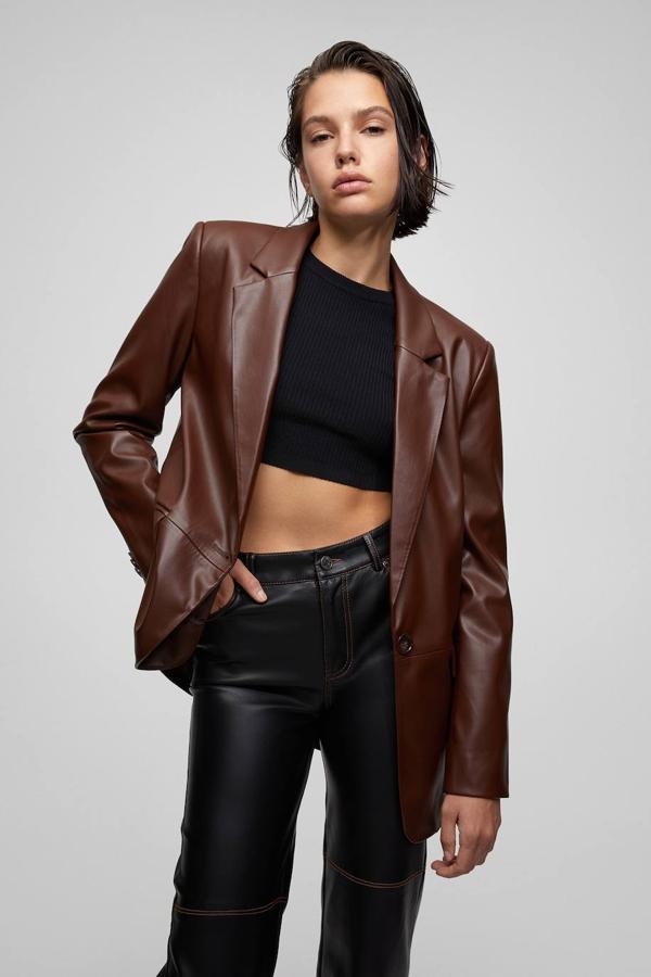 Blazer confeccionada en tejido efecto piel con corte ancho, manga larga, cuello solapa y bolsillos con tapeta, color marrón, de Pull&Bear. Hazte con ella con descuento a 19,99 euros.