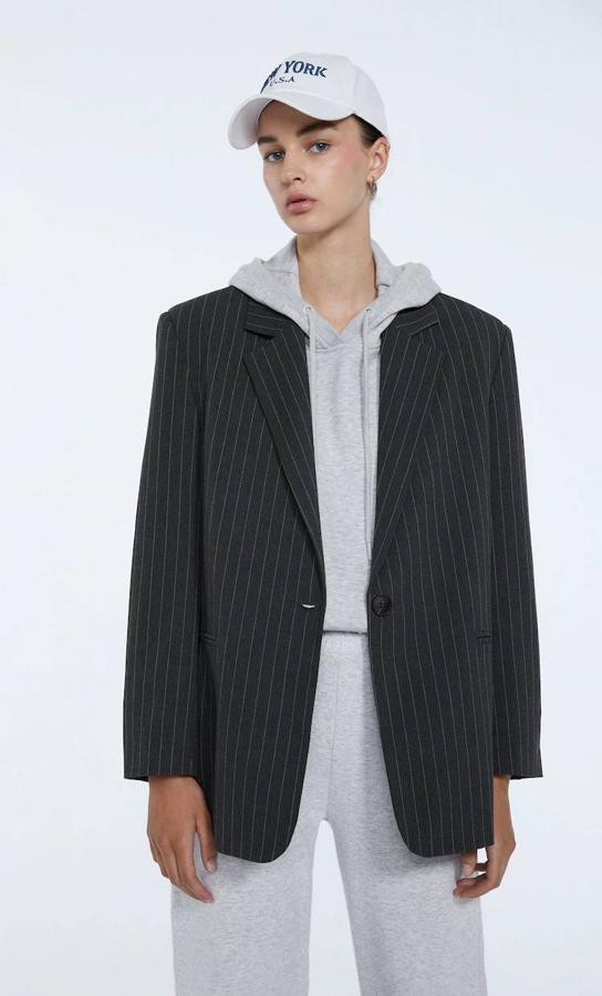 Americana oversize con hombros marcados, manga larga, cuello solapa y estampado de raya diplomática, de Stradivarius. La encontrarás a 19,99 euros.