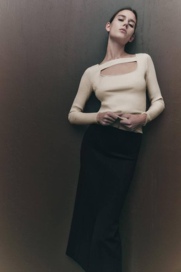 Falda midi de tubo con tiro alto, cintura elástica y abertura delantera en el bajo, en negro. Está rebajada a 12,99 euros.