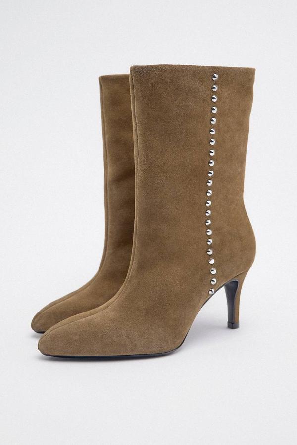 Botines con caña media ancha, efecto piel suave, detalles de tachas y tacón bajo, tono caqui, de Zara. Su precio es de 69,95 euros.