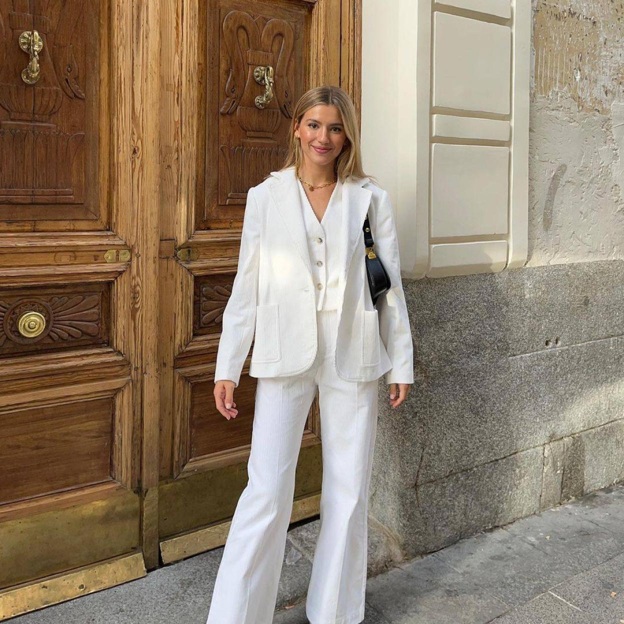 La influencer lleva un traje blanco con blazer, chaleco y pantalón