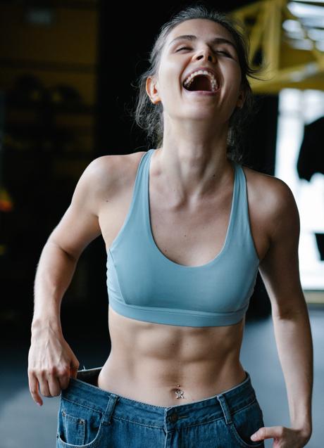 Imagen - Mujer sonriente con abdominales marcados/PEXELS
