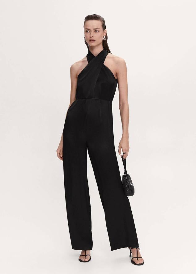 Mono en tejido satinado con escote cruzado tipo halter, perneras anchas y fluidas y cinturón de cordón, color negro. Lo conseguirás a 69,99 euros.