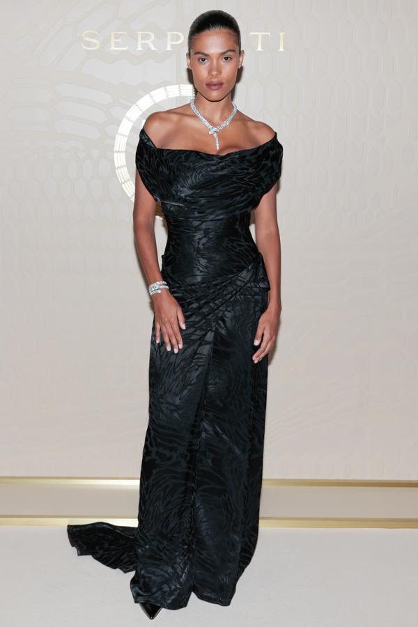 Tina Kunakey con un vestido negro de escote bardot.