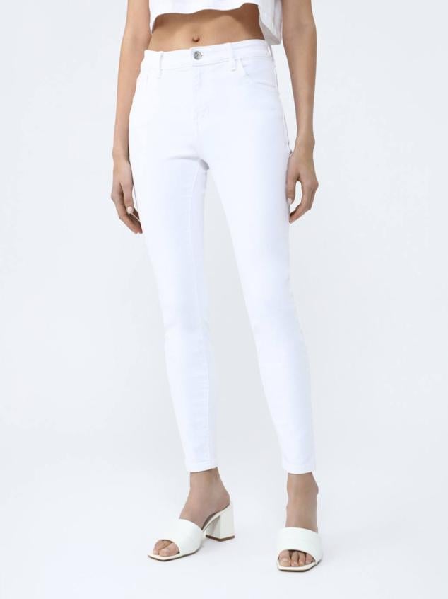 Pantalón vaquero skinny con cinco bolsillos, tiro medio y trabillas para el cinturón, color blanco, de Lefties. Su precio es de 12,99 euros.