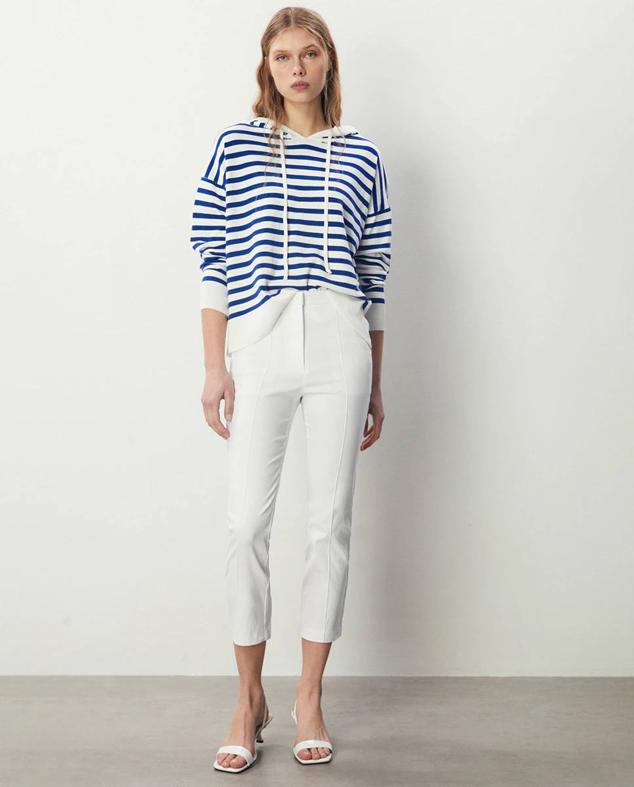 Pantalón liso en tejido satinado con perneras entalladas, corte capri y tiro alto, color blanco, de Sfera. Te costará 23,99 euros.