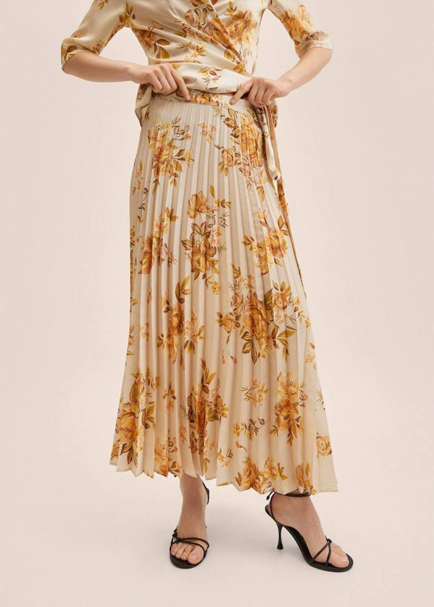 Falda midi plisada con tiro alto, bajo en evasé y estampado floral en crudo y ocre. Te costará 34,99 euros.