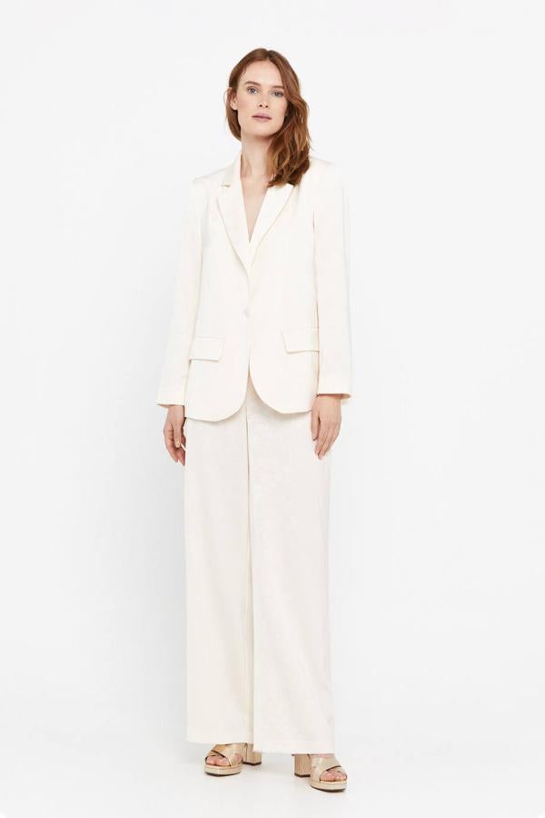 Traje en tejido jacquard luminoso con patrón de flores compuesto por americana recta y pantalón fluido, tono blanco marfil, de Cortefiel. Lo encontrarás por 99,99 euros y 59,99 euros.