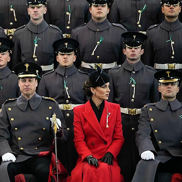 El abrigo de Kate de Alexander McQueen destacaba entre tanto uniforme gri, incluido el de su marido, el príncipe Guillermo, sentado a su lado.